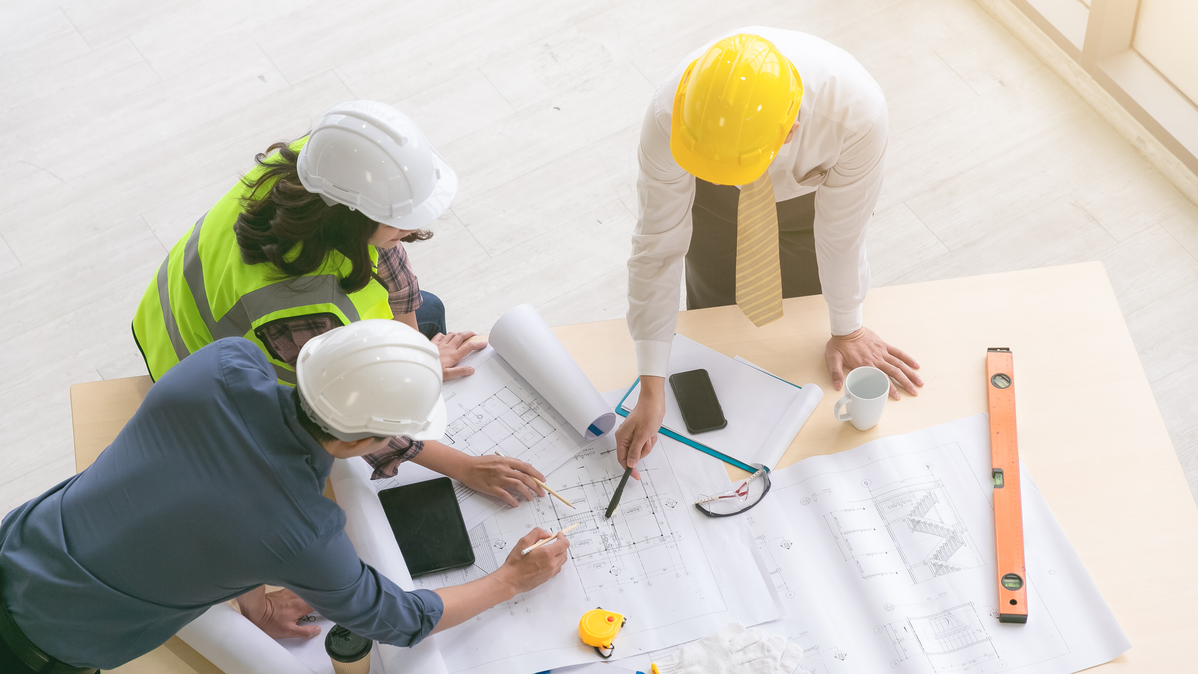 Team of engineers and architects working, planing, measuring layout of building blueprints in construction site. top view; Shutterstock ID 1795018936; purchase_order: NA; job: CJ Brian Ward January 2022; client: ; other: 