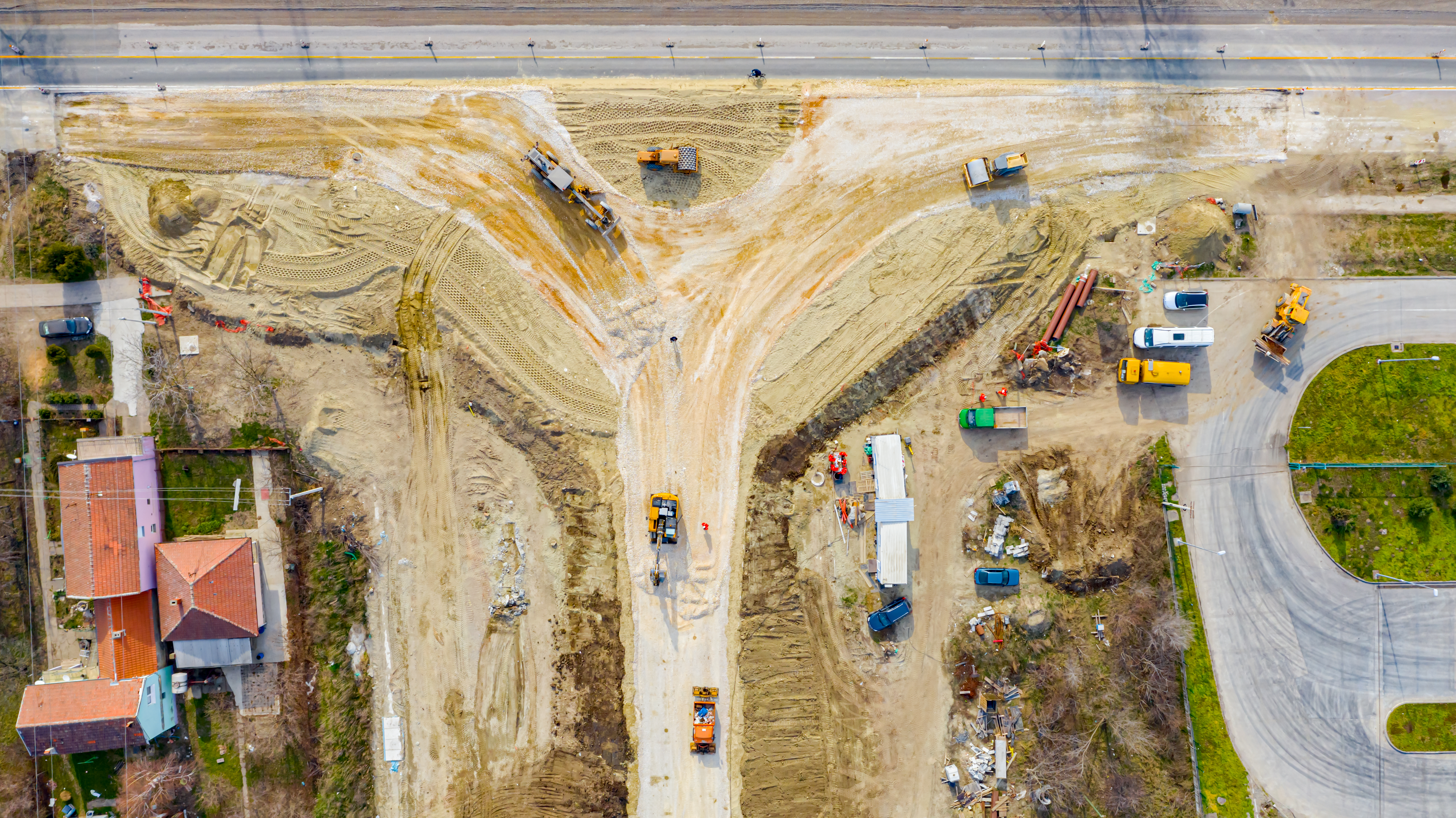 Above top view, overhead on circular road, roundabout under construction, crew of workers at building site working on road foundation with heavy machinery.; Shutterstock ID 1961028010; purchase_order: na; job: CJ_predictions_2023_January; client: ; other: 