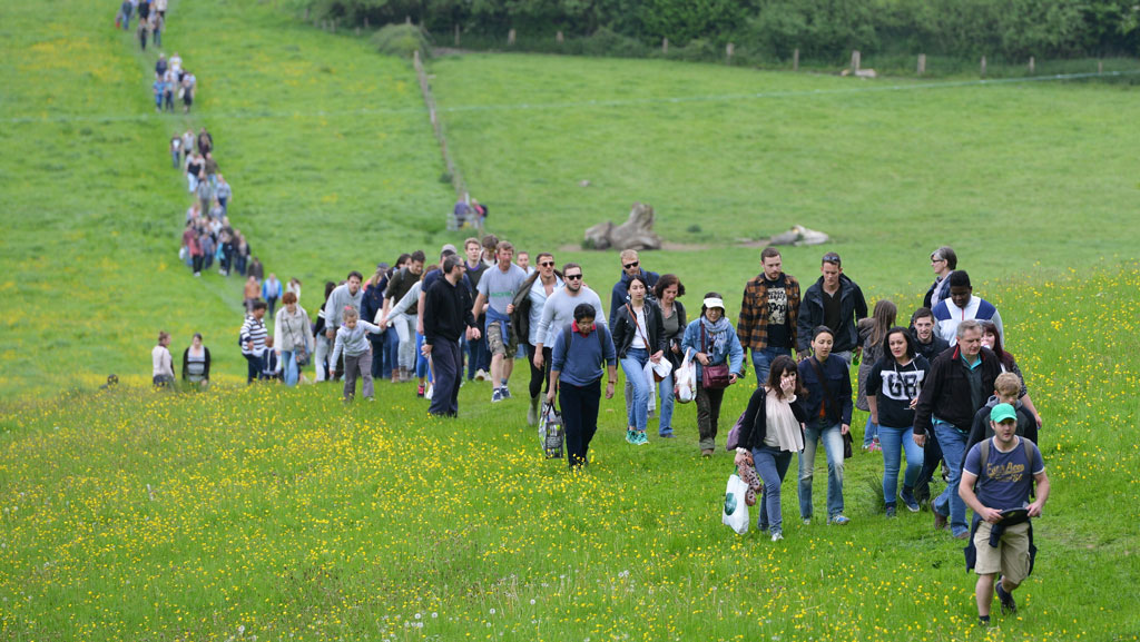 Group of people walking up a hill in countryside