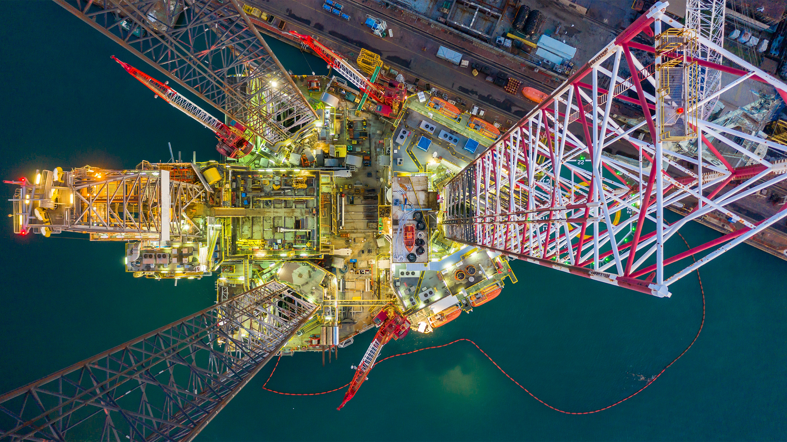Offshore vessel in floating dock and jack up rig under maintenance at night